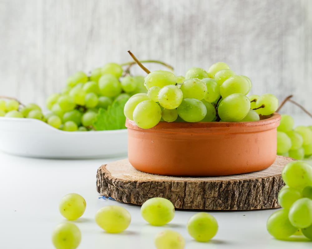 grape-clusters-with-wooden-piece-plates-white-surface1000 「夏至」的節氣芳療養生法:一忌體表的涼,二忌體內的涼
