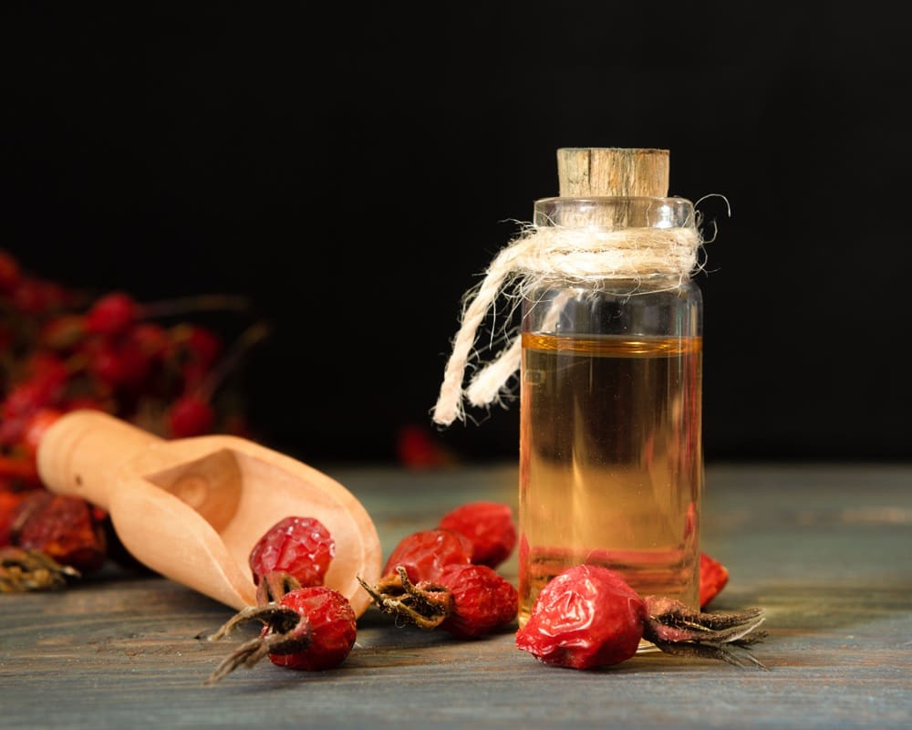 rose-hip-oil-wooden-boards-against-dark-background-bottle-tied-with-cord-with-dogrose-essential-oil1000800 玫瑰果基底油功效百科