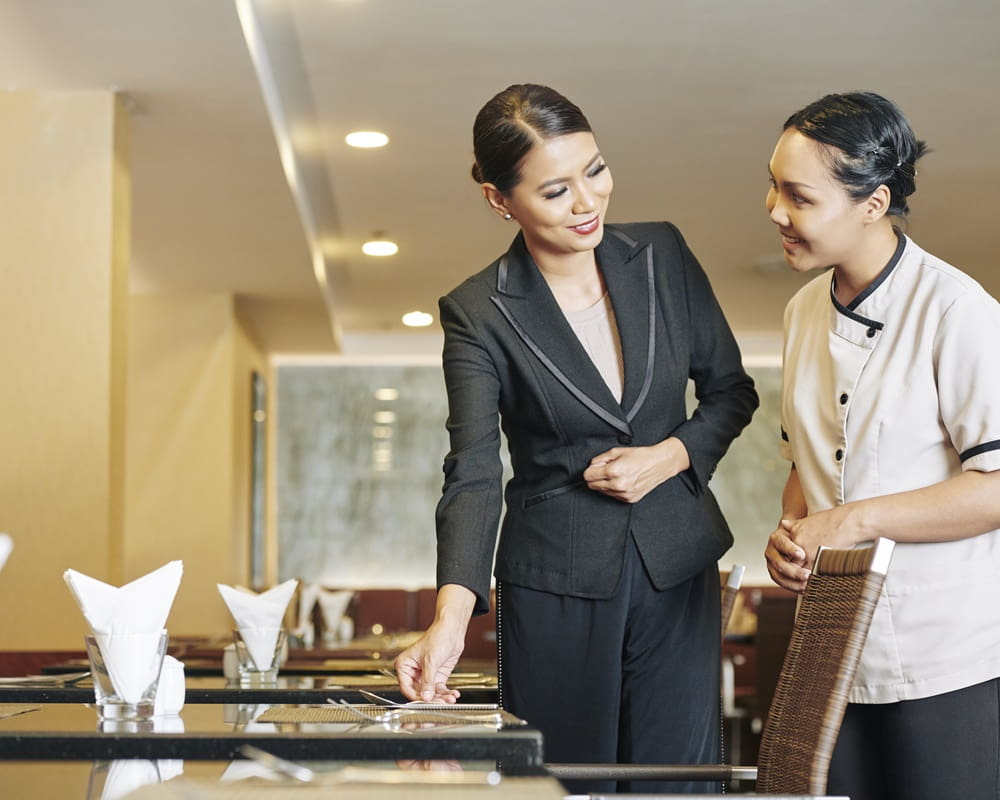 smiling-banquet-manager-explaining-head-waitress-how-place-fine-cutlery-dishes-tables1000 你對待工作的態度，決定你的吸金體質