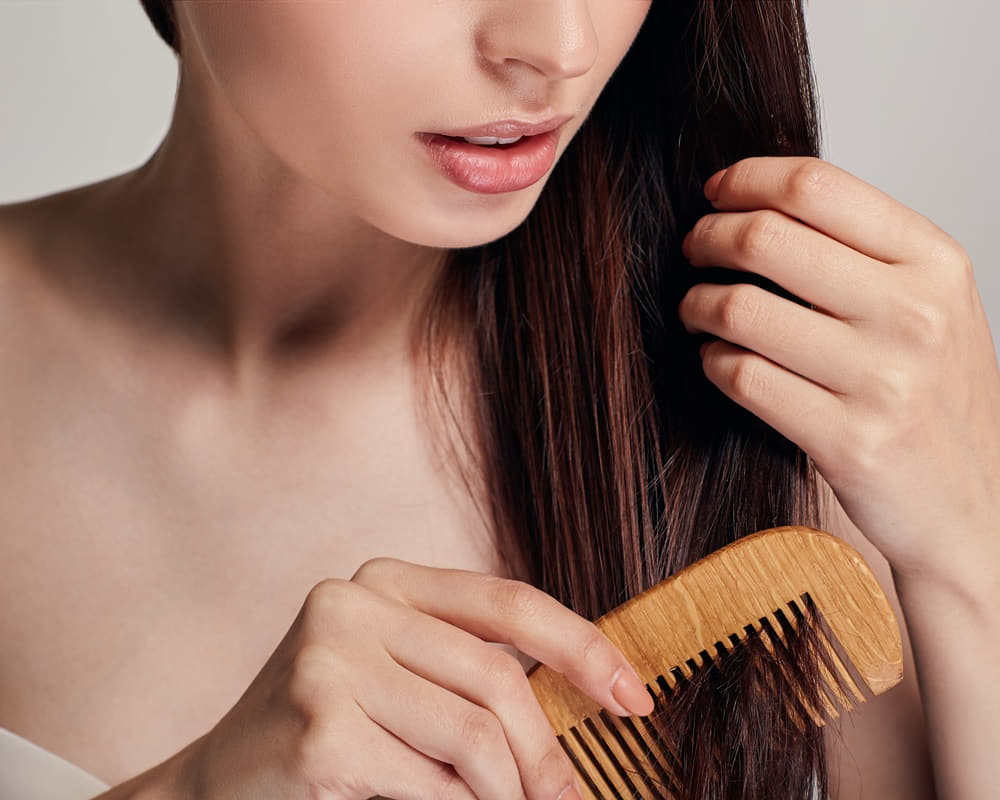 woman-with-playful-mood-combs-her-hair-with-light-brown-comb-by-right-hand-she-holds-hair-with-her-left-hand1000800 頭皮發癢、出油、掉屑 l 脂漏性皮膚炎與頭皮屑精油應用法
